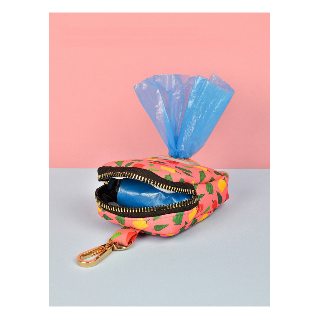 Pochette colorée ouverte contenant des sacs à déjections pour chien avec attache dorée.