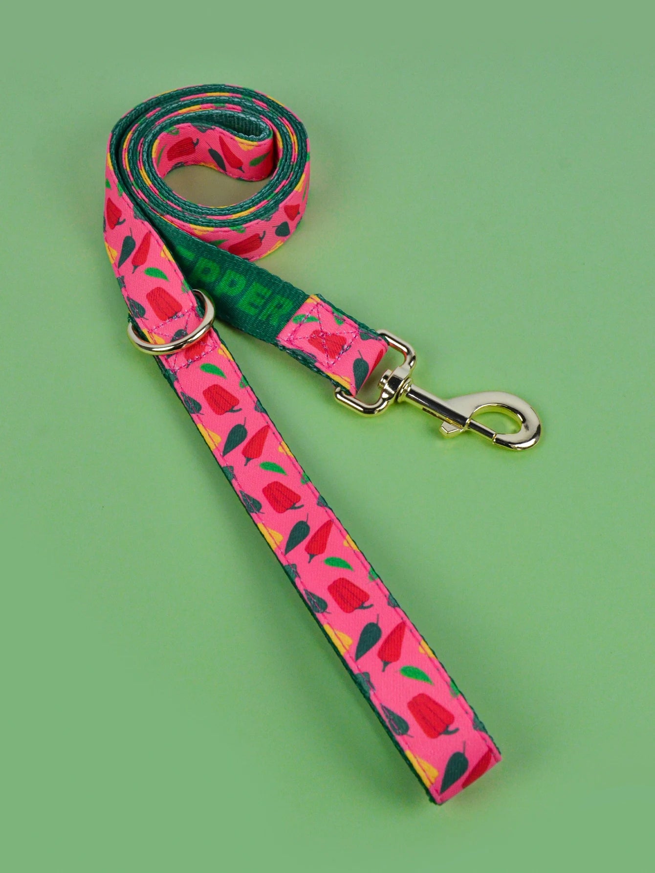 Laisse corde chien rose à motifs poivrons avec attache métal et collier assorti.