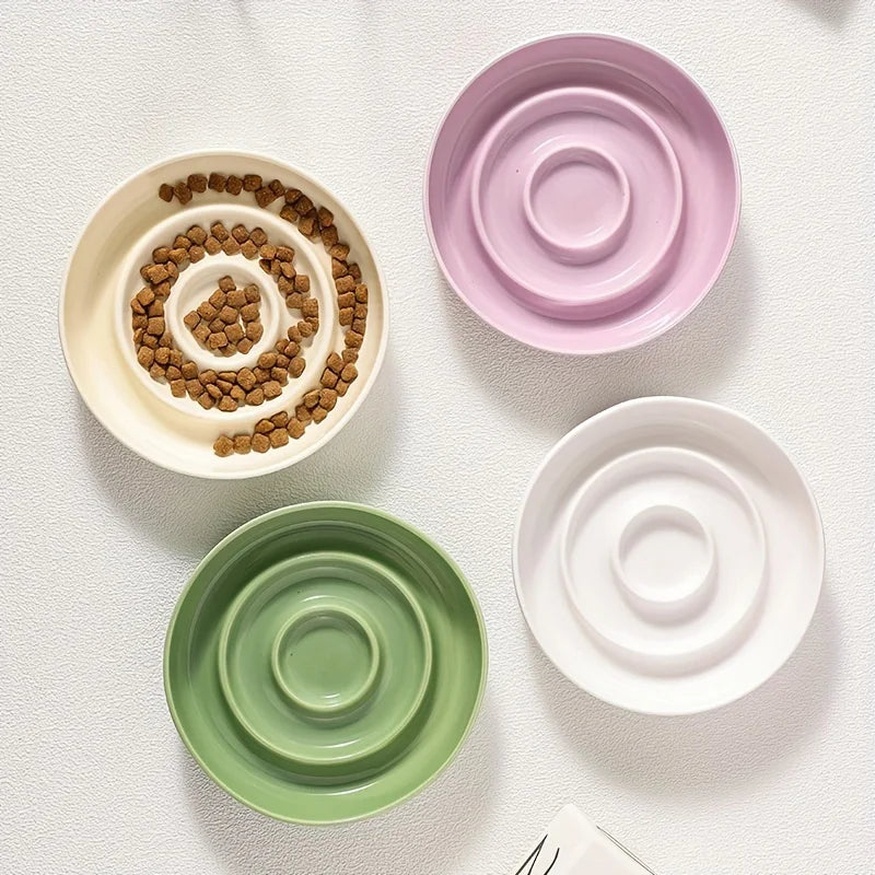 Gamelles anti-glouton en céramique blanc, violet et vert pour chien avec collier et laisse visibles.
