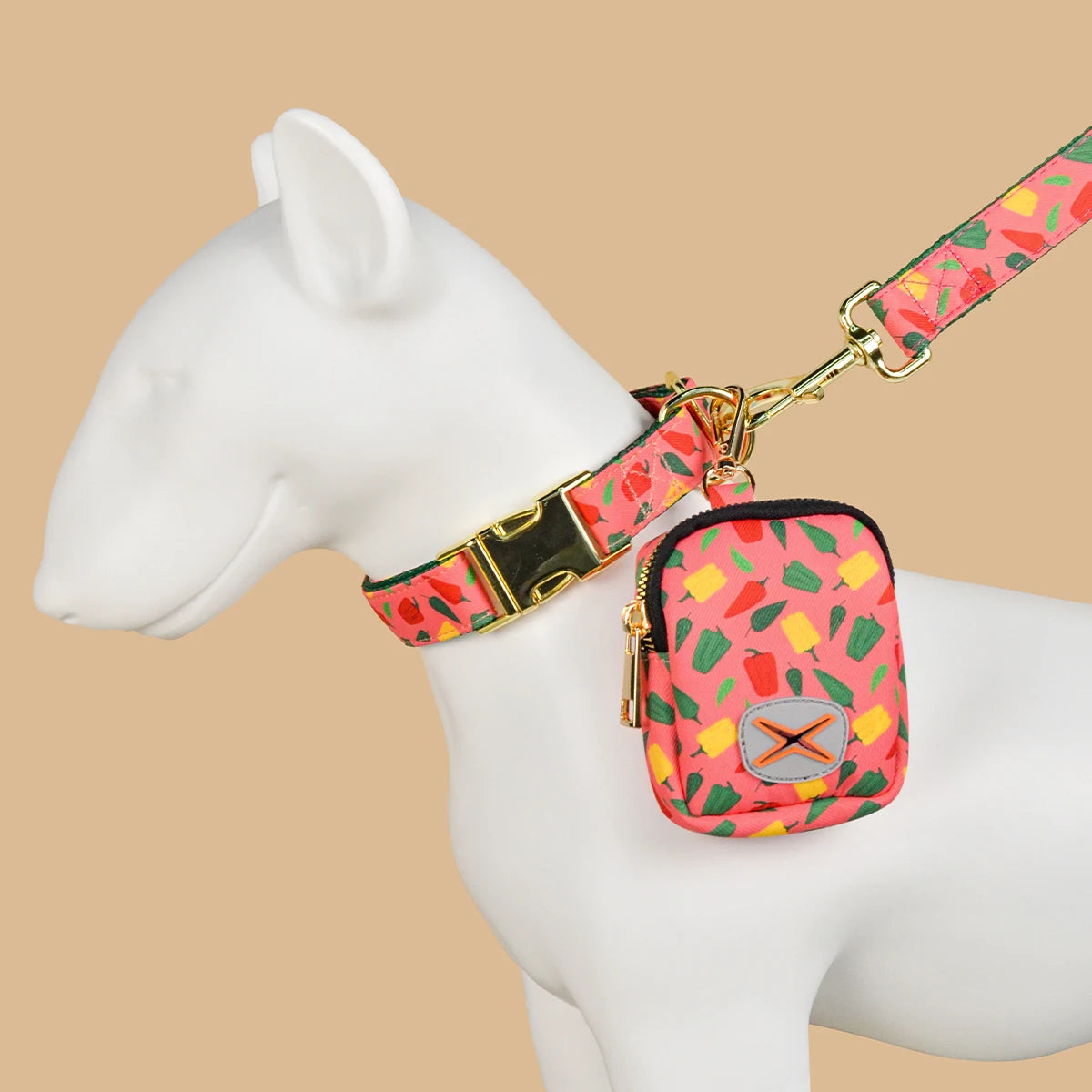 Collier chien rose avec motifs colorés et laisse assortie, gamelle portée en sac compact.