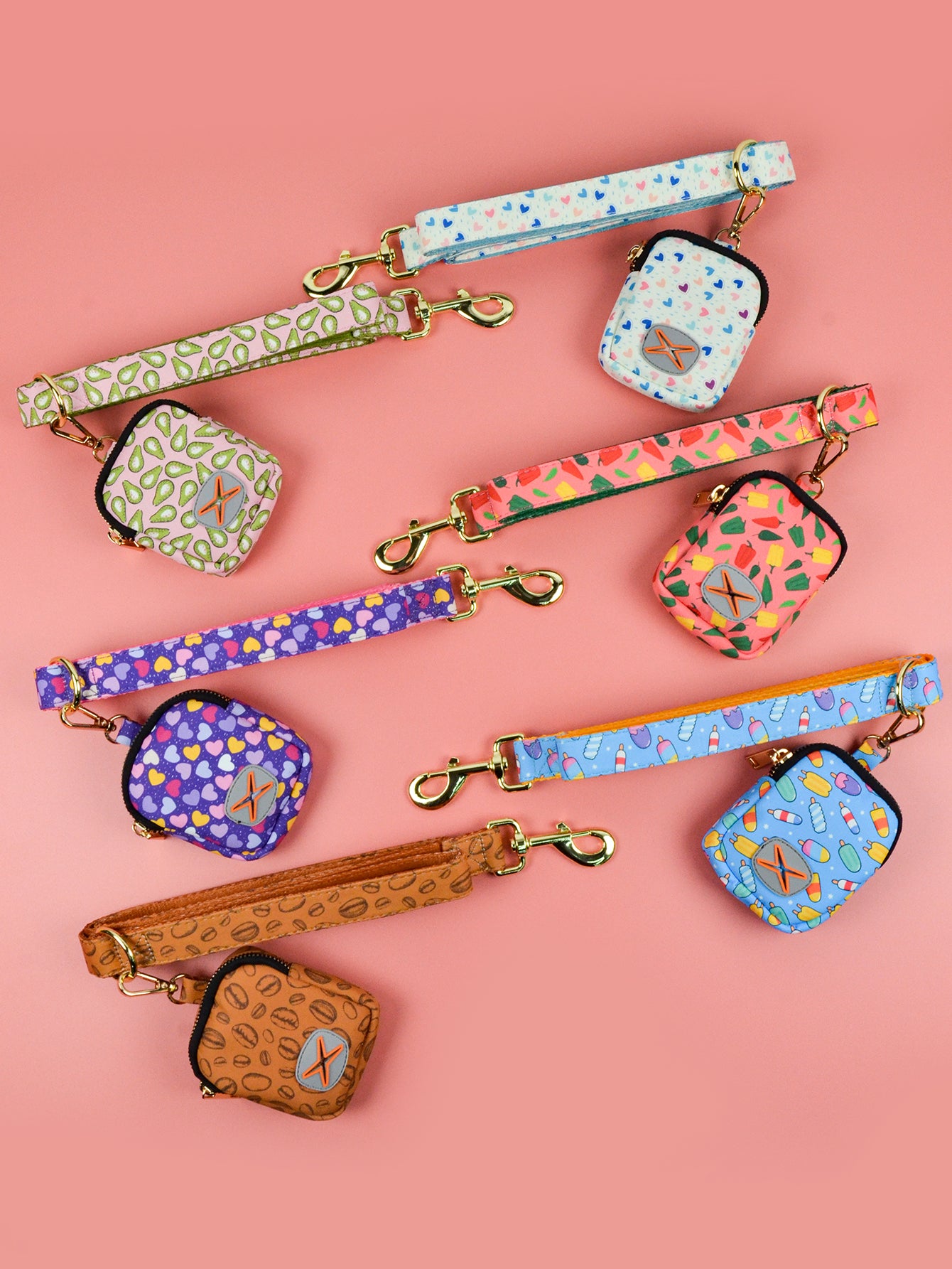 Ensemble laisse, gamelle et collier pour chien, motifs colorés variés sur fond rose.