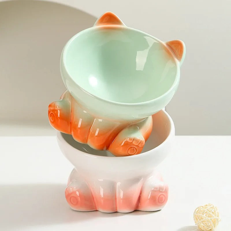 Gamelle en céramique grise et orange en forme de patte de chien, collier et laisse assortis visibles.